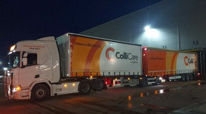 A branded ColliCare semi trailer during night, parked to the storage unloading goods
